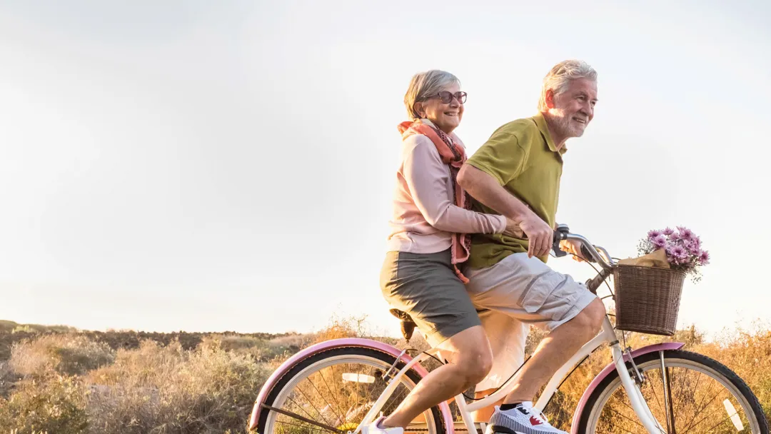 Older couple riding a bike together.