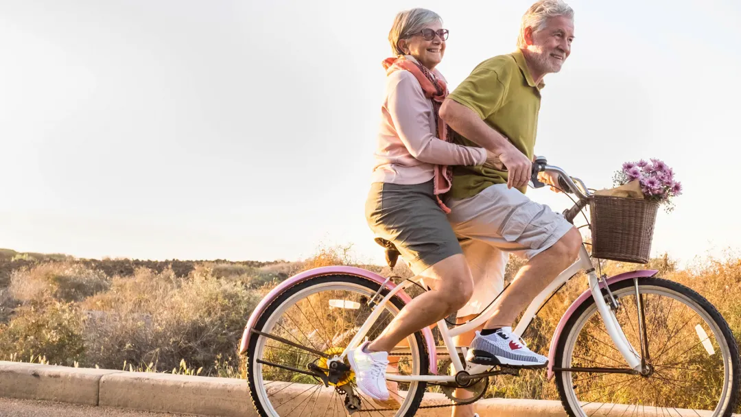 Older couple riding a bike together.