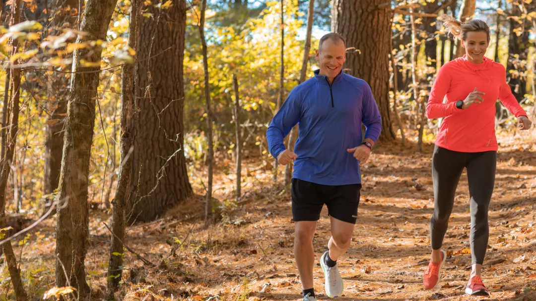 A Middle Aged Couple Goes For a Jog Through a Wooded Trail.