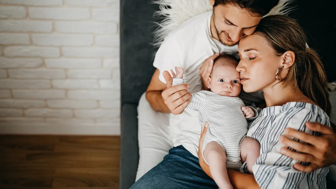 A Mother and Father Hug Their Newborn Baby