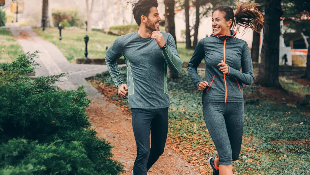 Two friends jogging in a park