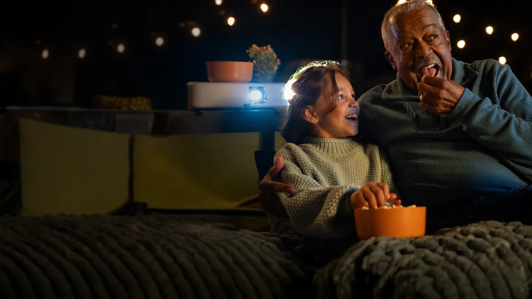 a man and his grandchild watching a movie