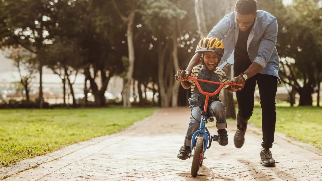 A father teaching his child how to ride a bike.