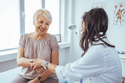 A Provider Holds a Smiling Patient's Hand