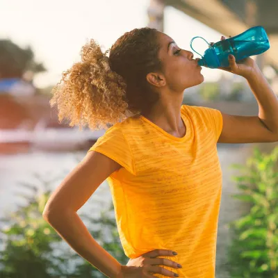 Woman on a run drinking water 