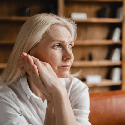 A Woman Thinks Deeply with Her Hand Pressed Against Her Face