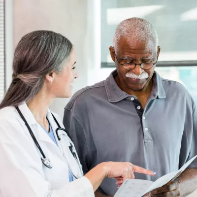 A Physician Goes Over a Chart with a Patient 