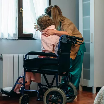 Woman embracing elderly woman in hospice