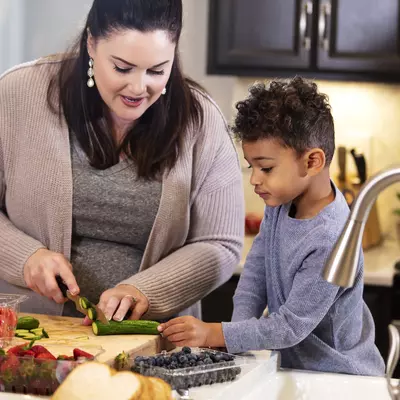 Woman Chopping Veggies with her son