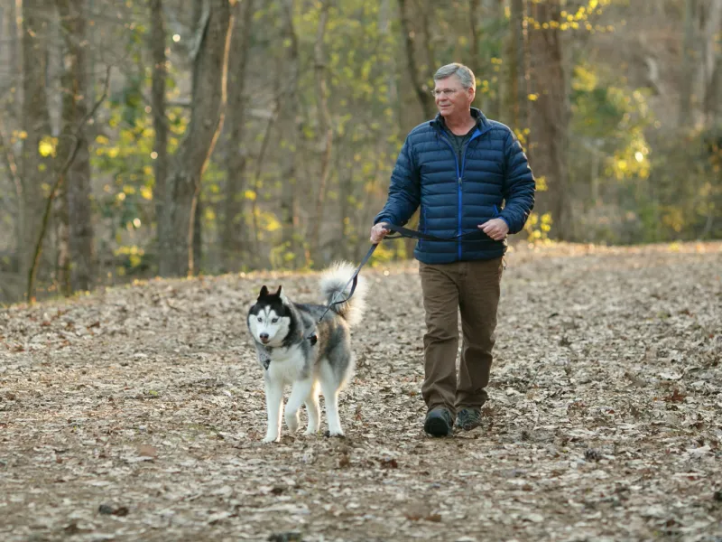 Mark and his dog walking in the woods
