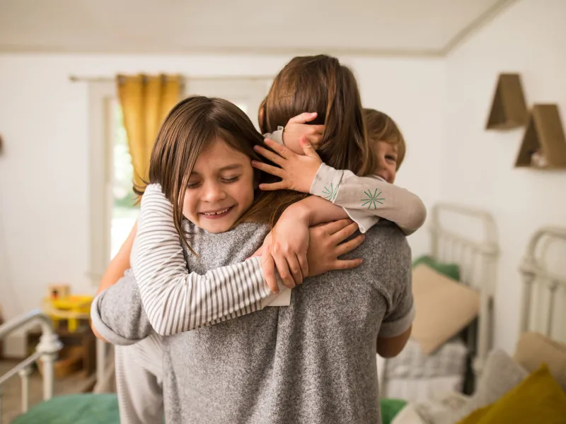A mom getting warmed hugs from her kids.