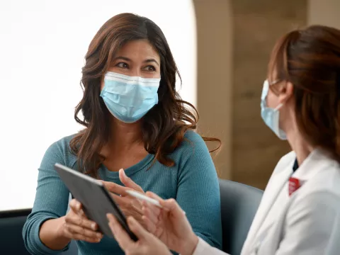 A Woman Consults With Her Doctor with a Tablet.
