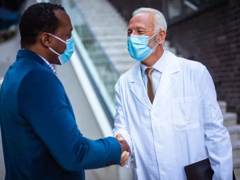 A gentleman shaking a doctor's hand