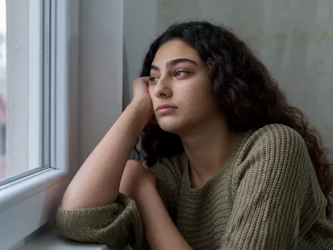 A Woman Stares Longingly Out a Window
