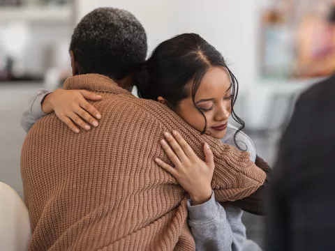 Two People Embrace While Sitting on a Couch.
