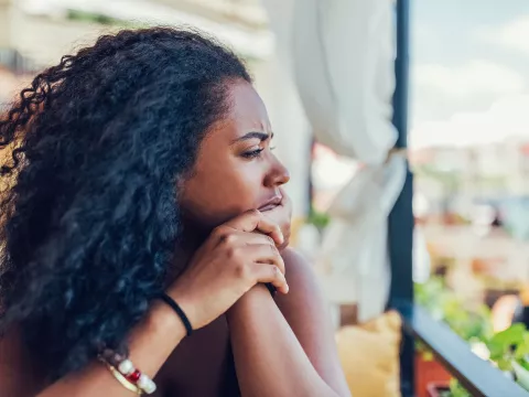 A Woman Stares into the Distance with a Worried Look on Her Face.