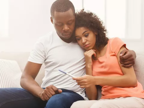 A Couple Embraces While Waiting for the Results of a Home Pregnancy Test.