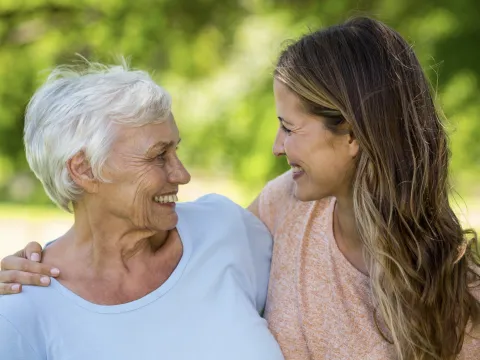 Two women smiling and hugging.