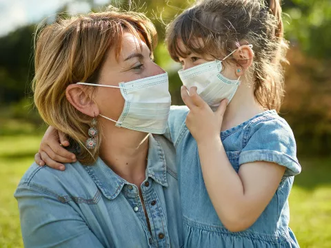 A mom and daughter wearing face masks.