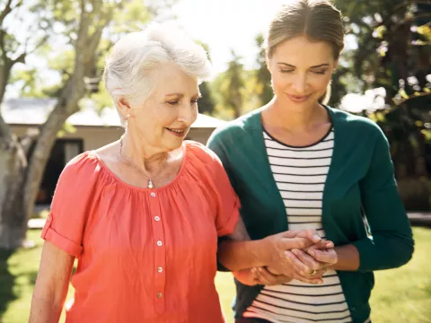 A mother and daughter, walking outside, offer emotional support to each other.