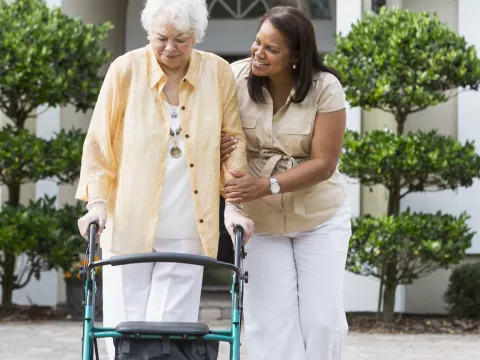 Woman in her driveway using a walker