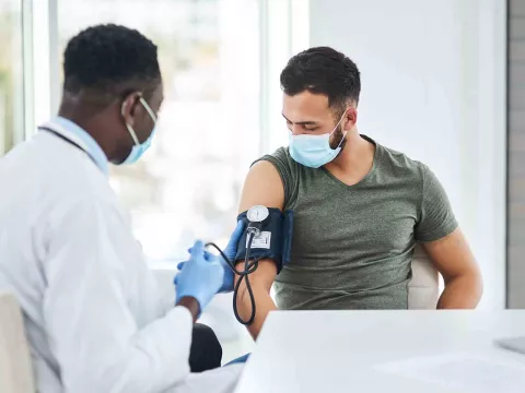 Male doctor wearing mask with male patient