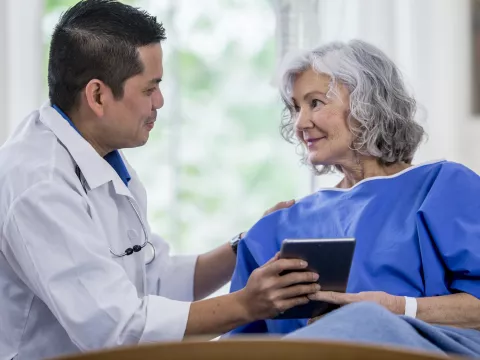 A male doctor and a senior woman patient, consulting.