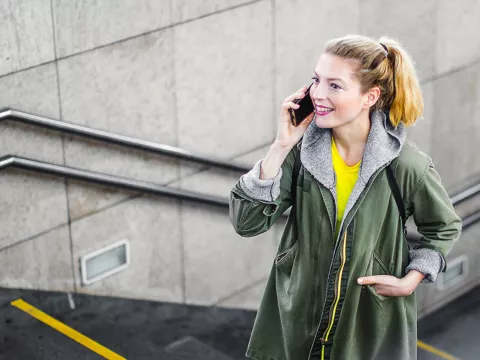A woman walking up stairs while talking on the phone