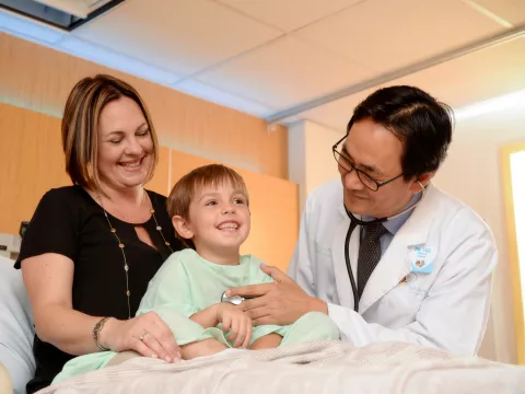 Photo of Doctor checking on pediatric patient and mom
