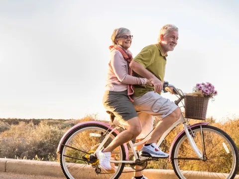 Older couple riding a bike together.