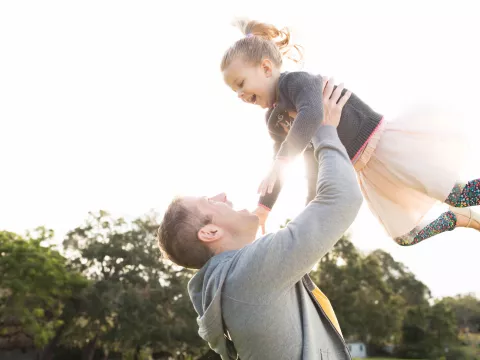 Daughter flying with Father outdoors