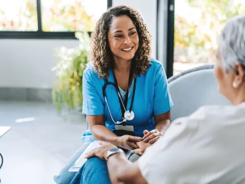 Healthcare professional talking to patient at home