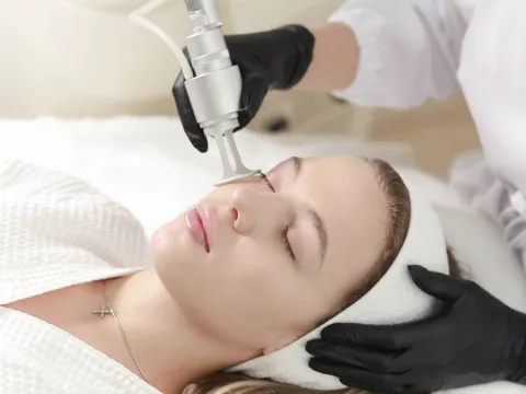 A woman receiving laser treatments on her face.