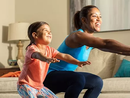 Mom and young daughter doing squats