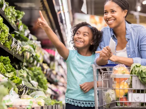 A mother and daughter shop for nutrient-rich vegetables at the supermarket.