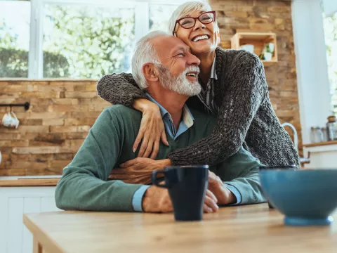A couple hugging in the kitchen.