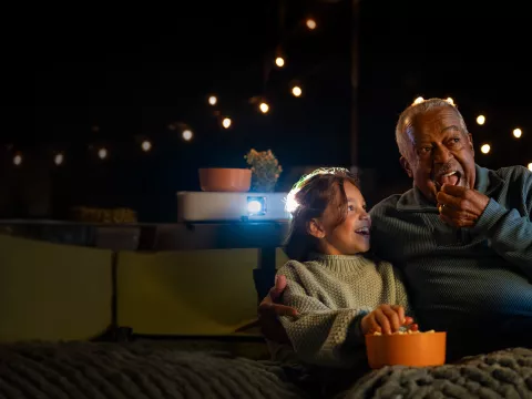a man and his grandchild watching a movie
