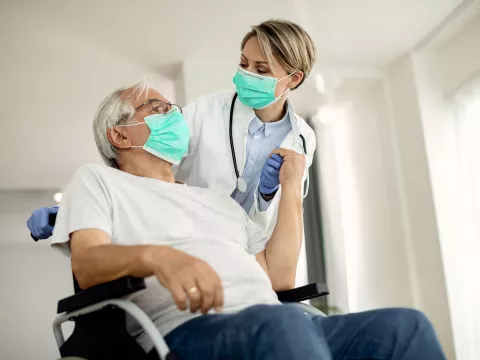 A senior man being assisted by a nurse