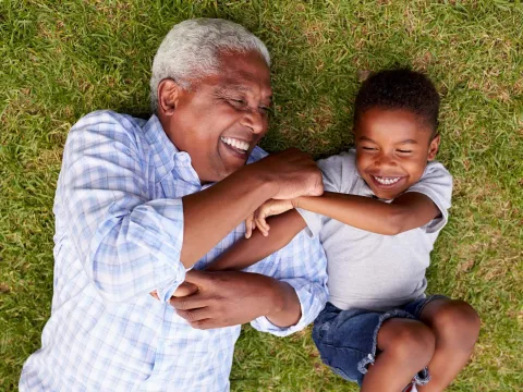 A grandfather playing with his young grandson.