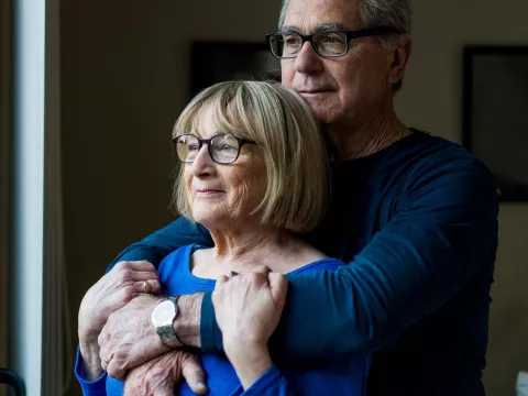 Elderly white couple embracing