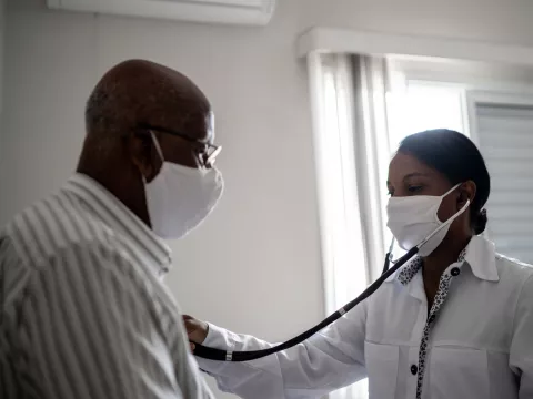 A doctor using a stethoscope on a patient