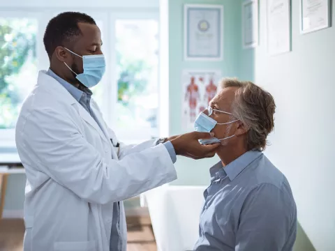 A male doctor examining a male patient. 
