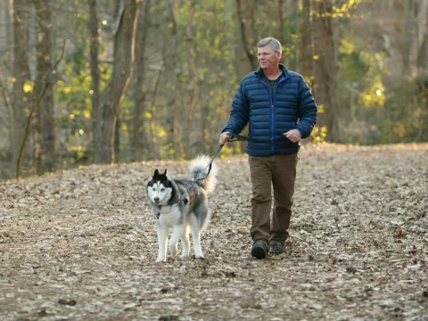 Mark and his dog walking in the woods