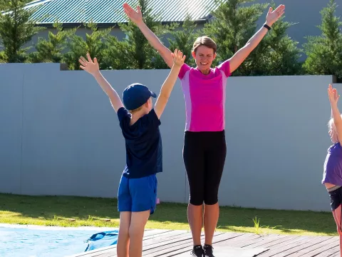 A mom does PE at home with her kids.