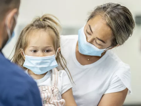 A mother at the doctor's office with her daughter.