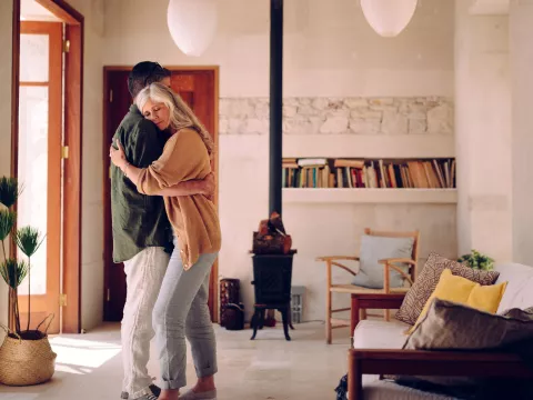 A mature man and woman embrace in their living room