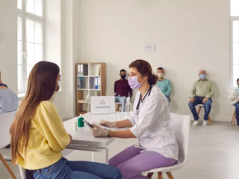 A nurse talking to a patient at a vaccine site