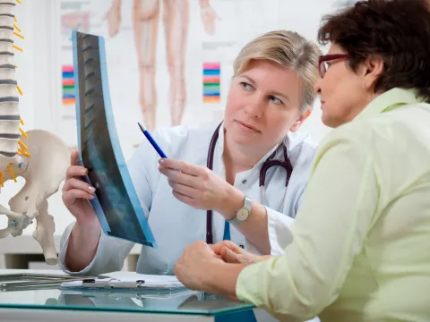 A woman looks at her back x-ray with her doctor