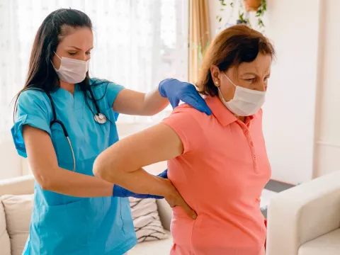 A woman being treated for back pain by her doctor. 