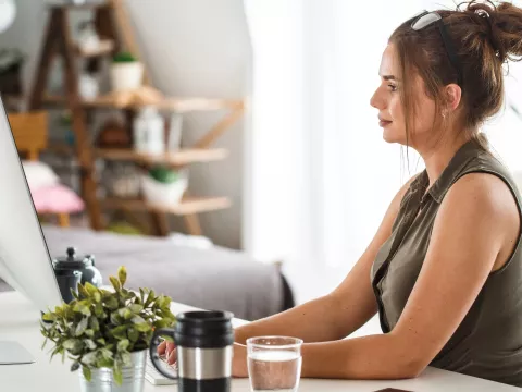 A woman sits with good posture while working at her desk.